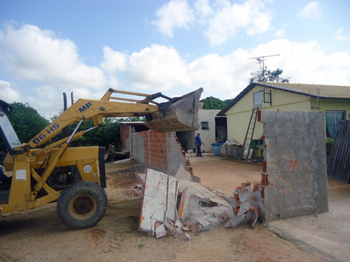 Na ocasião, quatro muros, que estavam ocupando uma área que não pertencia ao terreno dos moradores, foram derrubados (Foto: Divulgação)